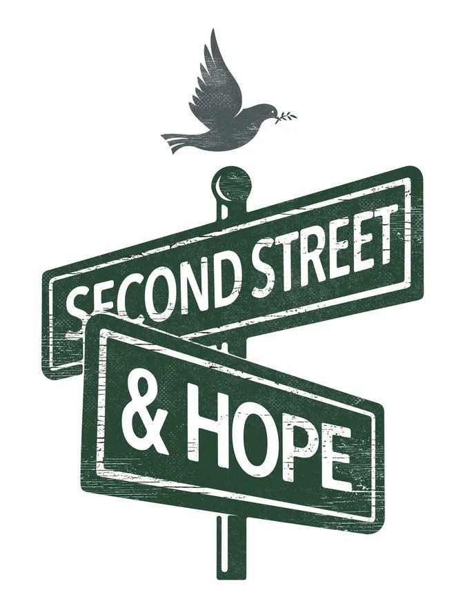 A bird is flying over a street sign that says second street and hope.