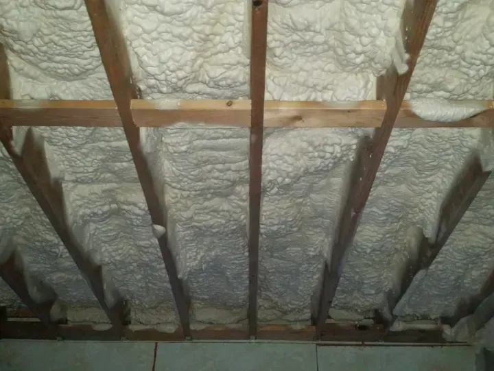 A ceiling with a lot of foam on it and wooden beams.