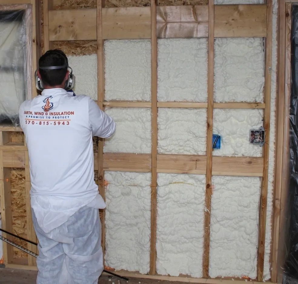 A man wearing a white shirt that says insulation on the back