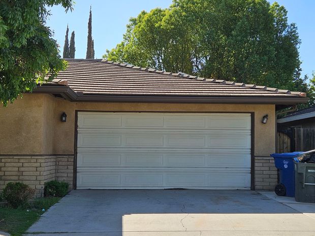 A white garage door is open in front of a house