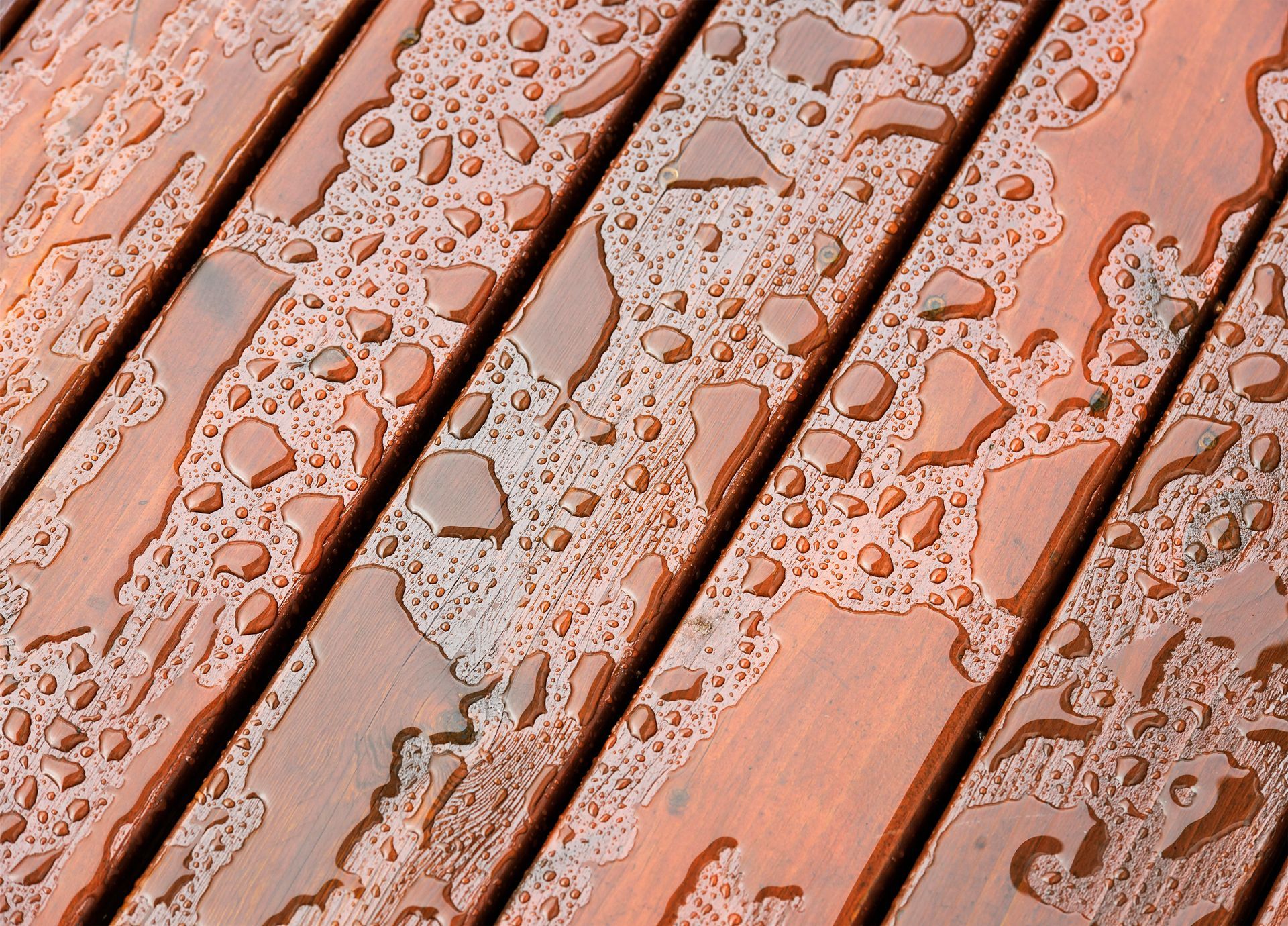Wooden deck planks with water droplets.