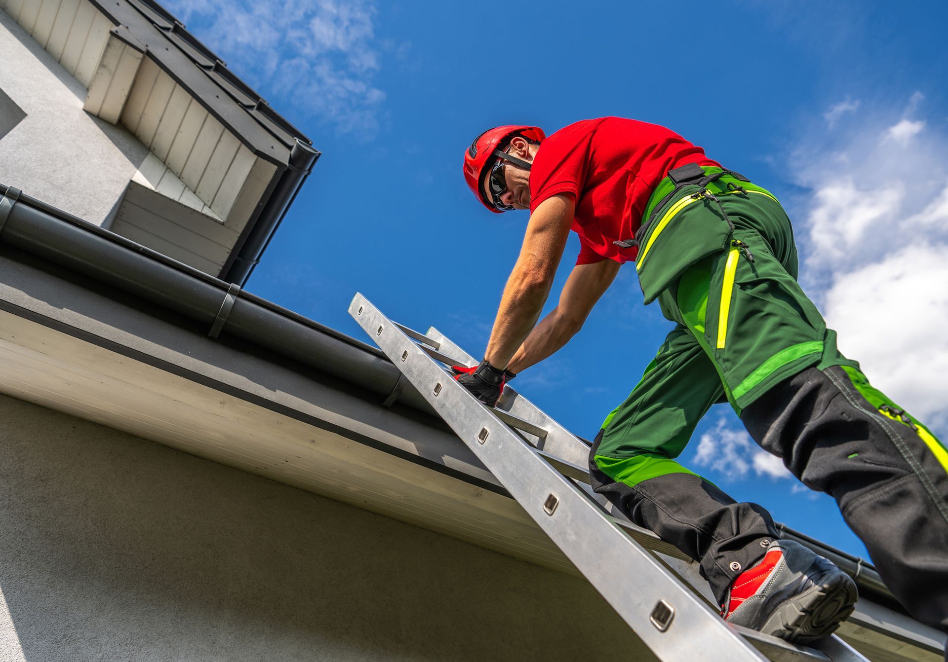 A man is inspecting the gutter of a house. A man is inspecting the gutter of a house.