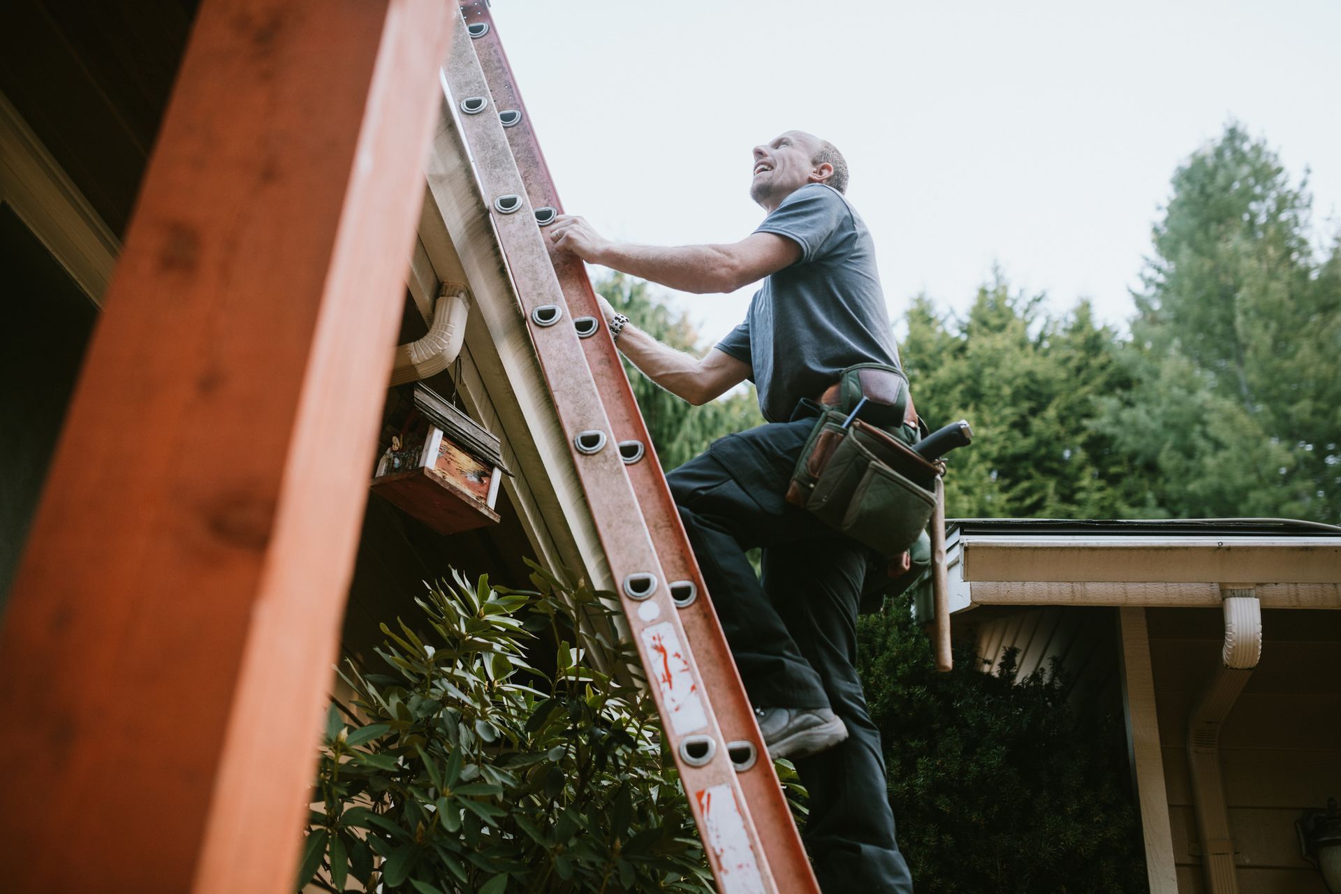A roofer and crew work on putting in new roofing shingles.