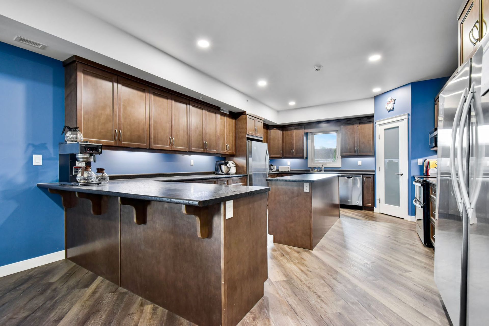 A large kitchen with stainless steel appliances and wooden cabinets.