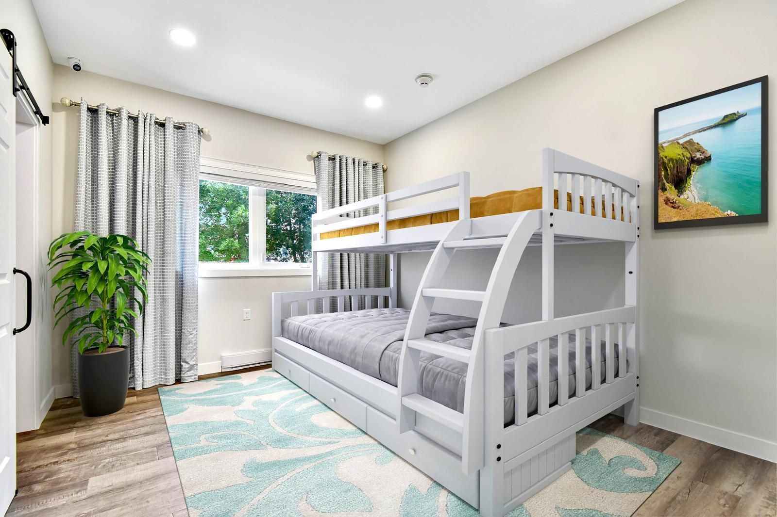 A bedroom with a bunk bed and a picture on the wall.