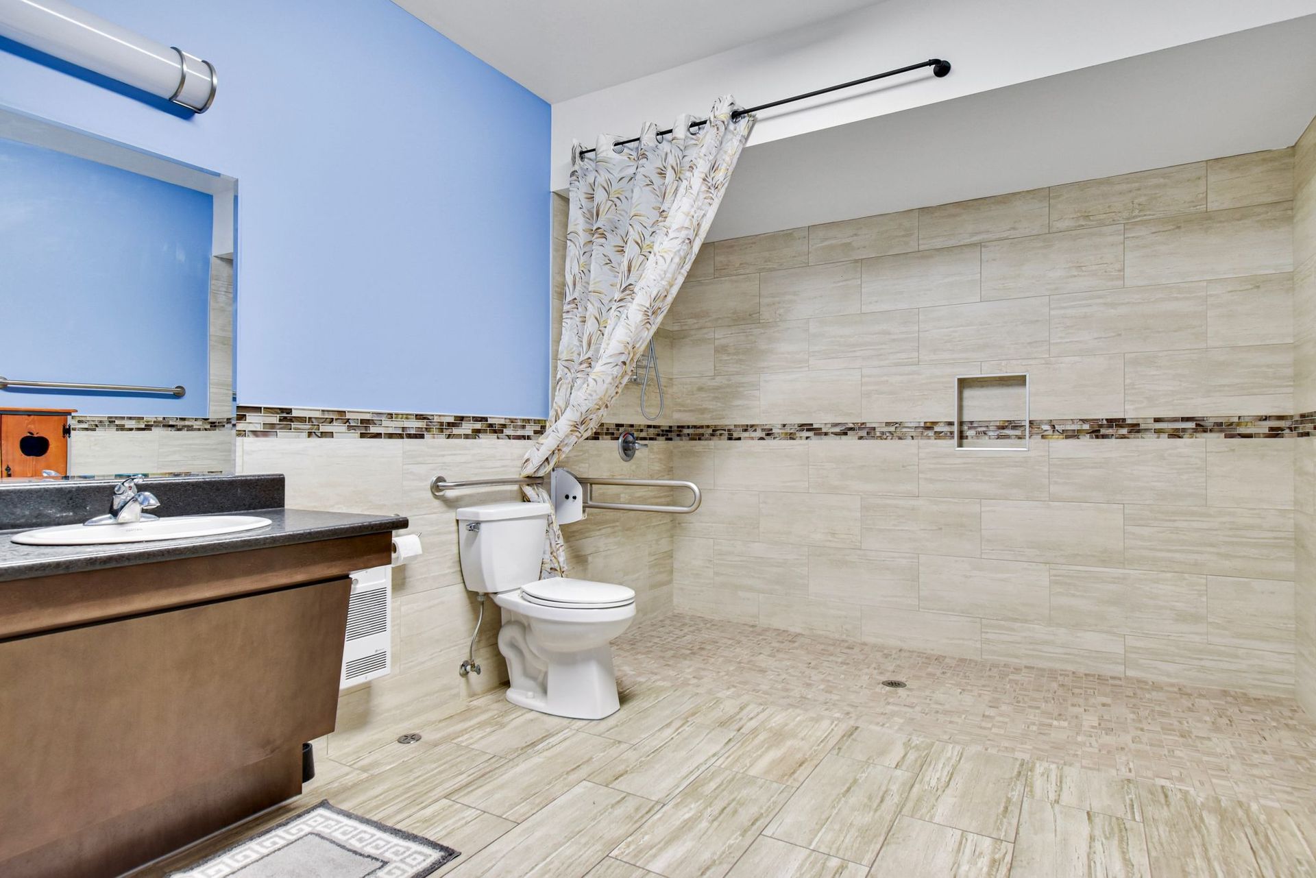 A bathroom with a toilet , sink , and walk in shower.