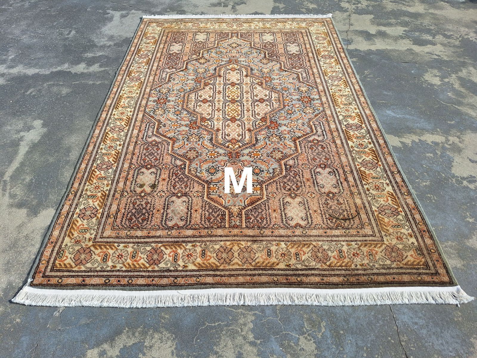A rug is sitting on top of a concrete floor.