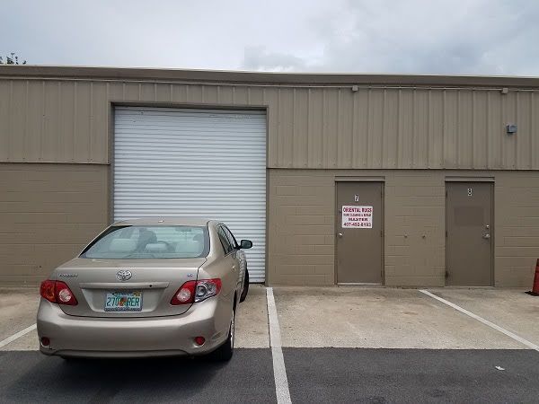 A car is parked in front of a building with a garage door