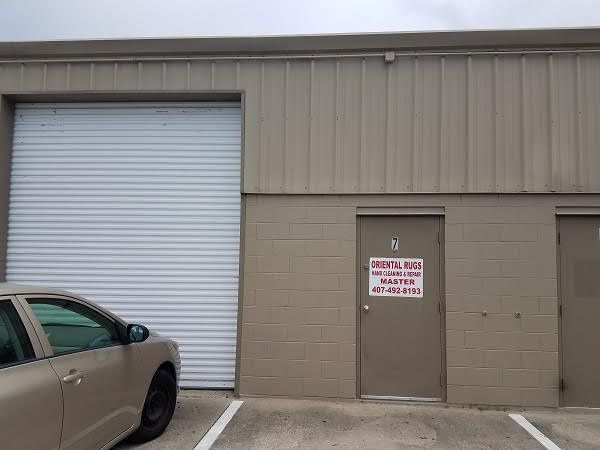 A car is parked in front of a building with a garage door