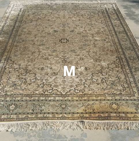 A large rug is sitting on a concrete floor.