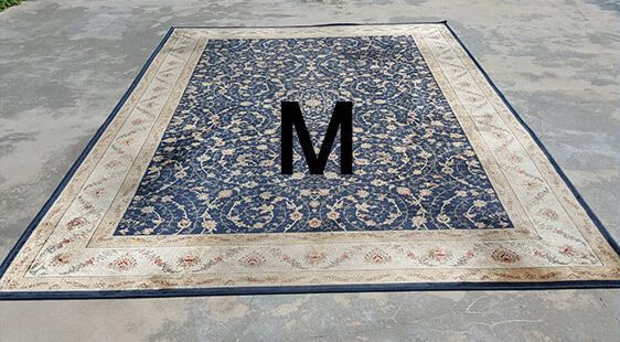 A rug with the letter m on it