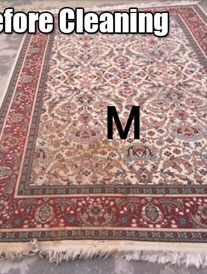 A rug with the letter m on it before cleaning.