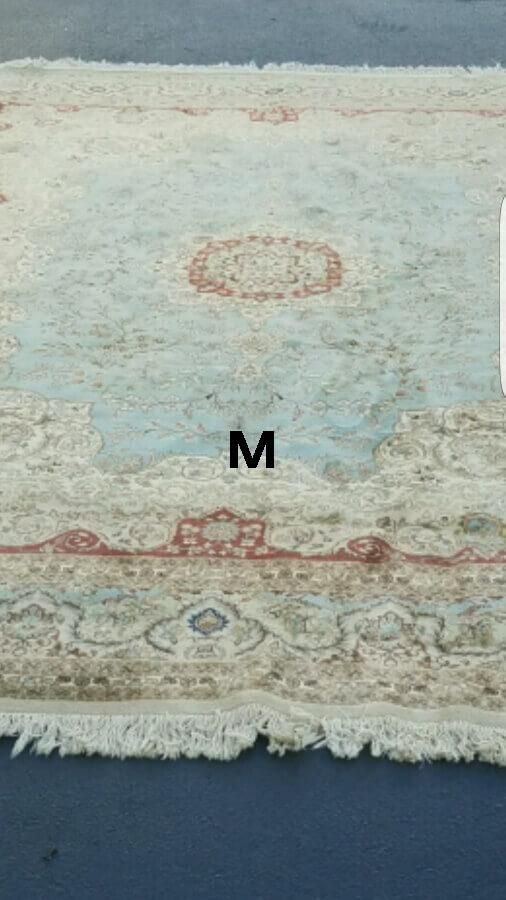 A rug with the letter m on it is sitting on a table.