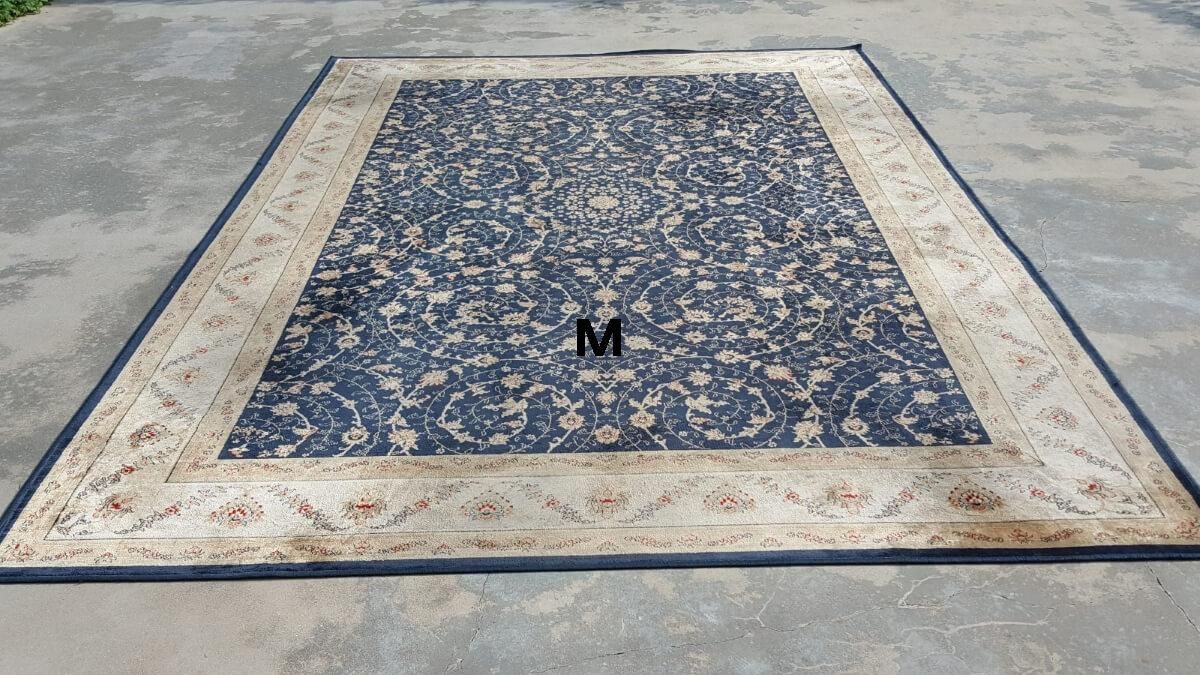 A large rug is sitting on top of a concrete floor.