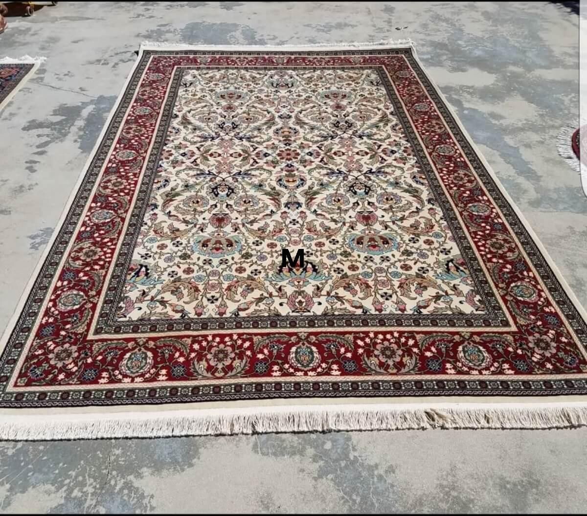 A large rug is sitting on top of a concrete floor.