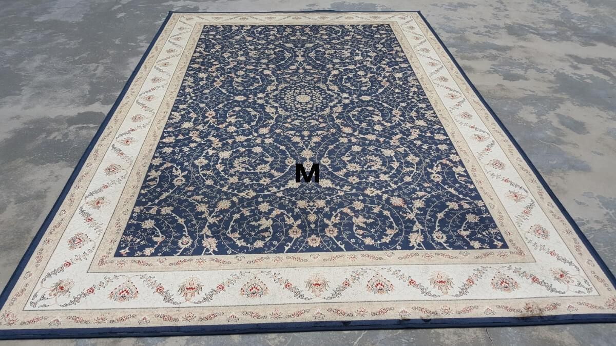 A blue and white rug with the letter m on it