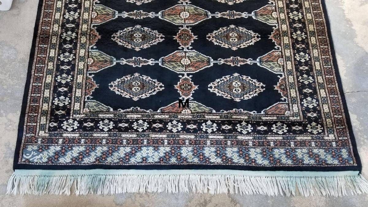 A rug with a fringe is sitting on the ground