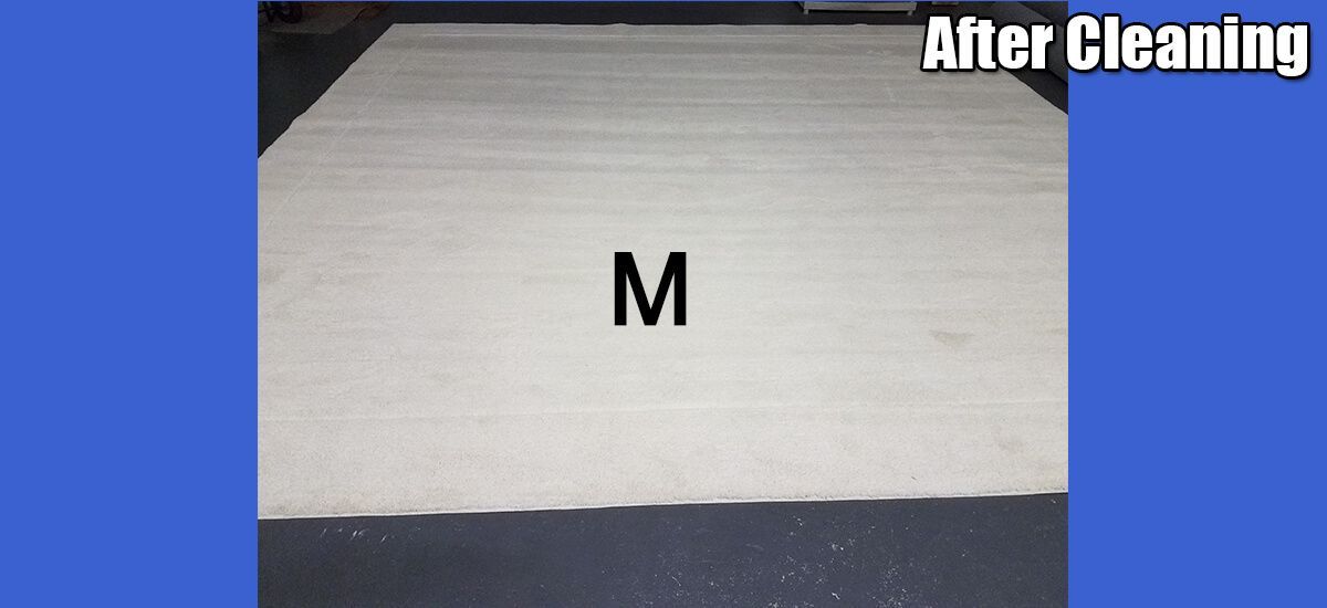 A white rug with the letter m on it