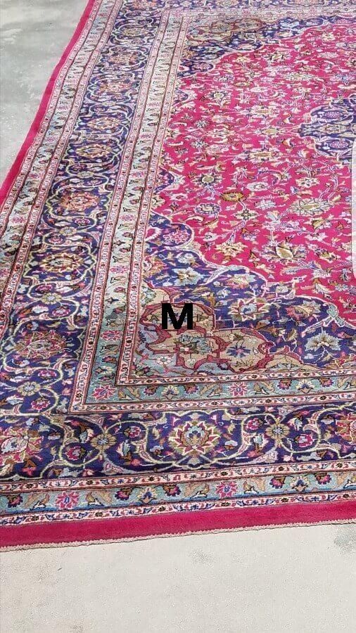 A close up of a rug with the letter m on it.