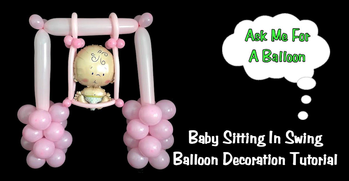 Baby sitting in a swing balloon decoration.