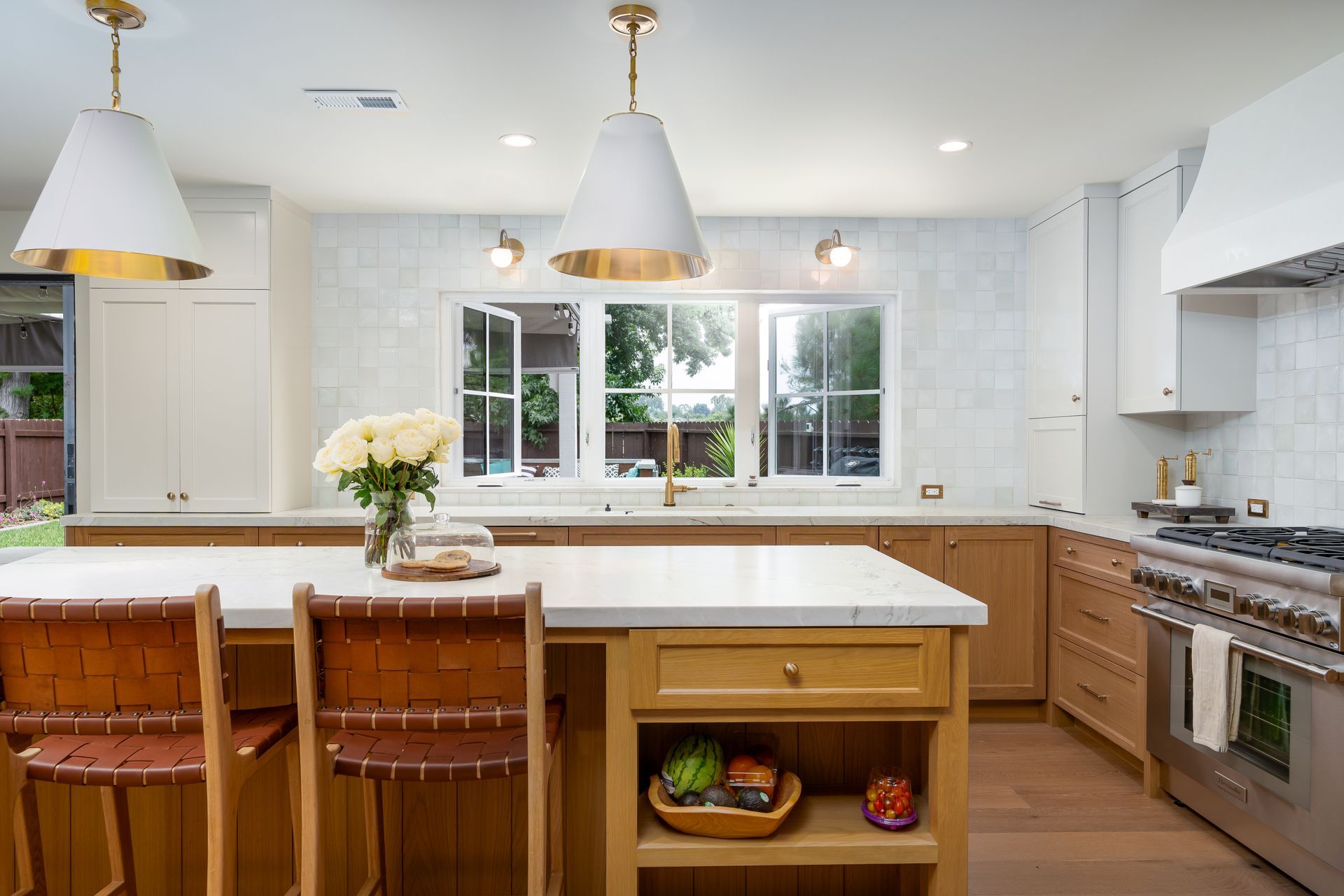 Modern kitchen with wooden cabinets, white countertops, and gold accents.