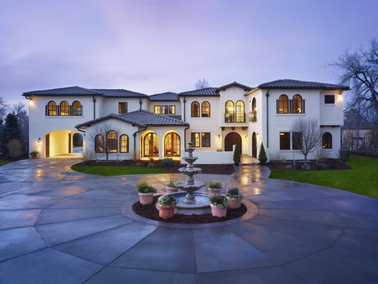 Elegant, multi-story Mediterranean-style home with a fountain in the driveway.