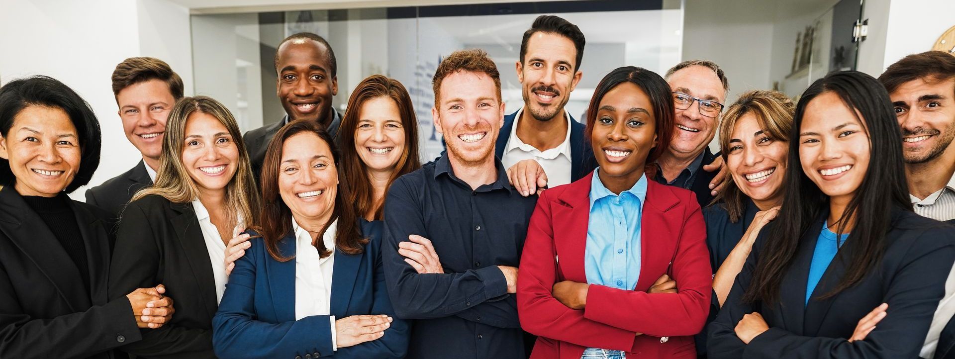 Group of diverse professionals smiling and posing with arms crossed.