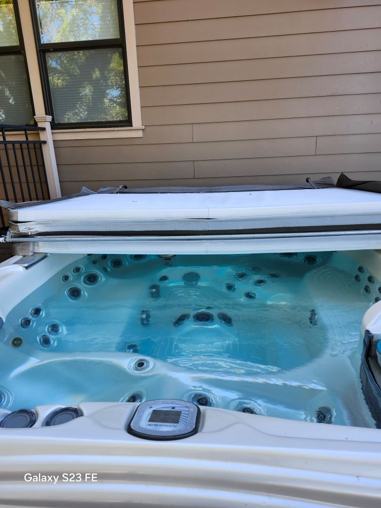 A large hot tub is sitting outside of a house.