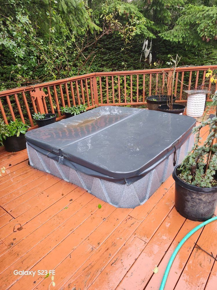 A hot tub is sitting on top of a wooden deck.