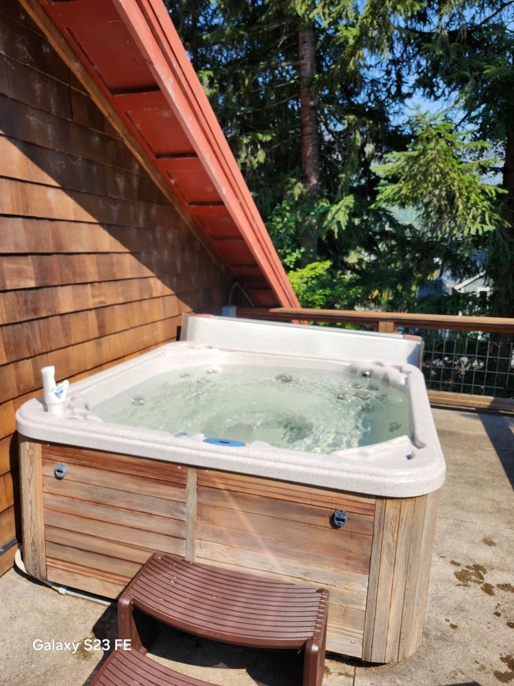A hot tub is sitting on top of a wooden deck.