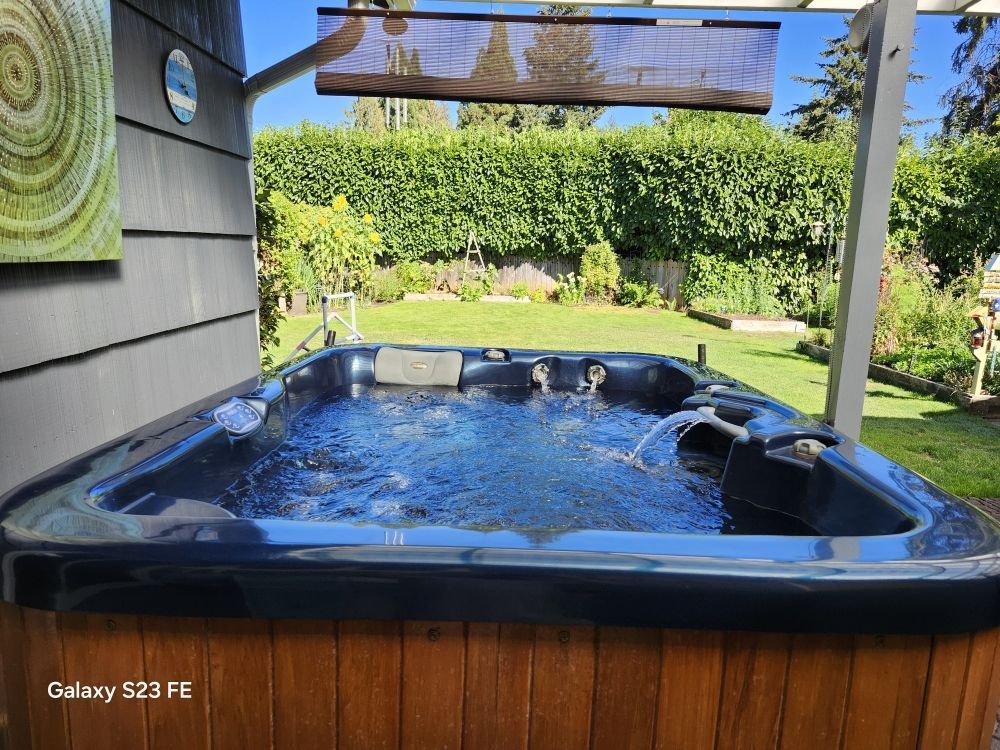 A hot tub is sitting in the backyard of a house.