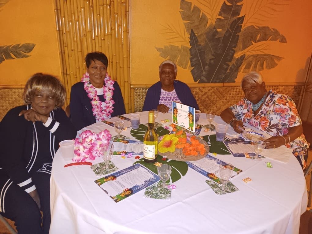 Four women are sitting around a table with a bottle of wine on it
