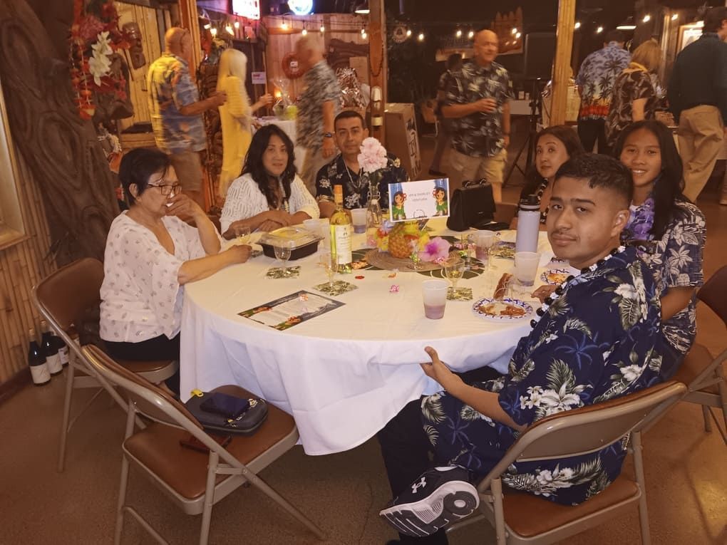 A group of people are sitting around a table in a restaurant.