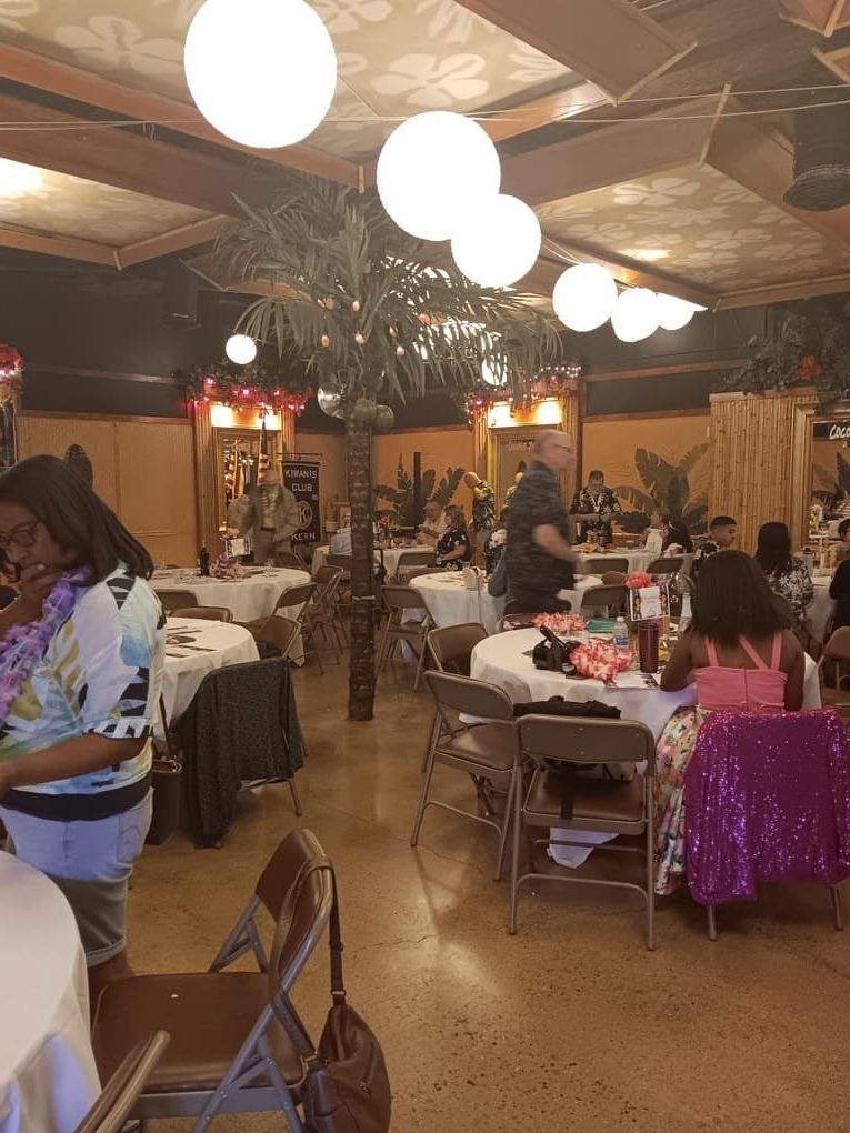 A group of people are sitting at tables in a large room