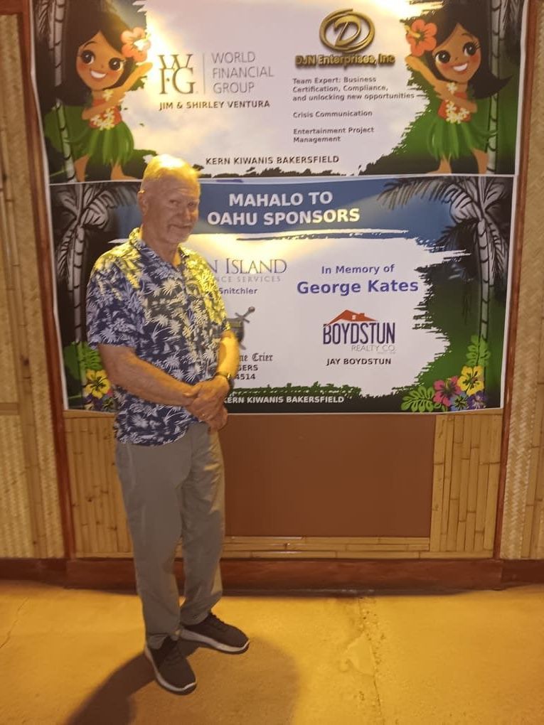 A man is standing in front of a sign that says mahalo to oahu sponsors