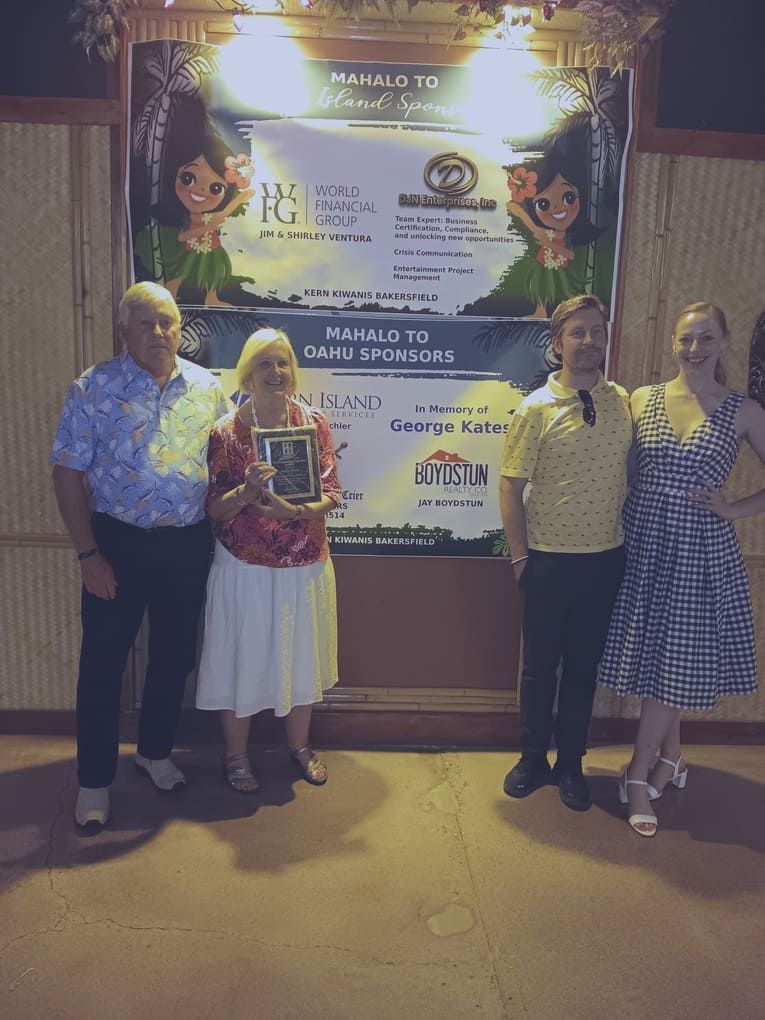 A group of people standing in front of a sign that says ' hawaii ' on it
