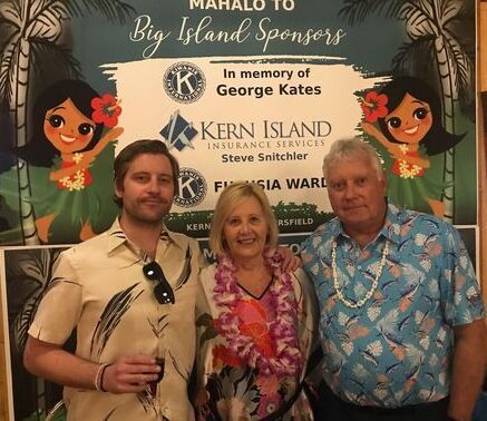 A group of people standing in front of a sign that says big island sponsors