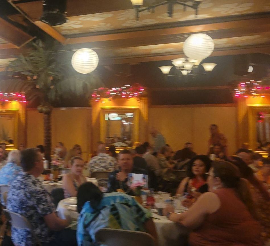 A group of people are sitting at tables in a restaurant