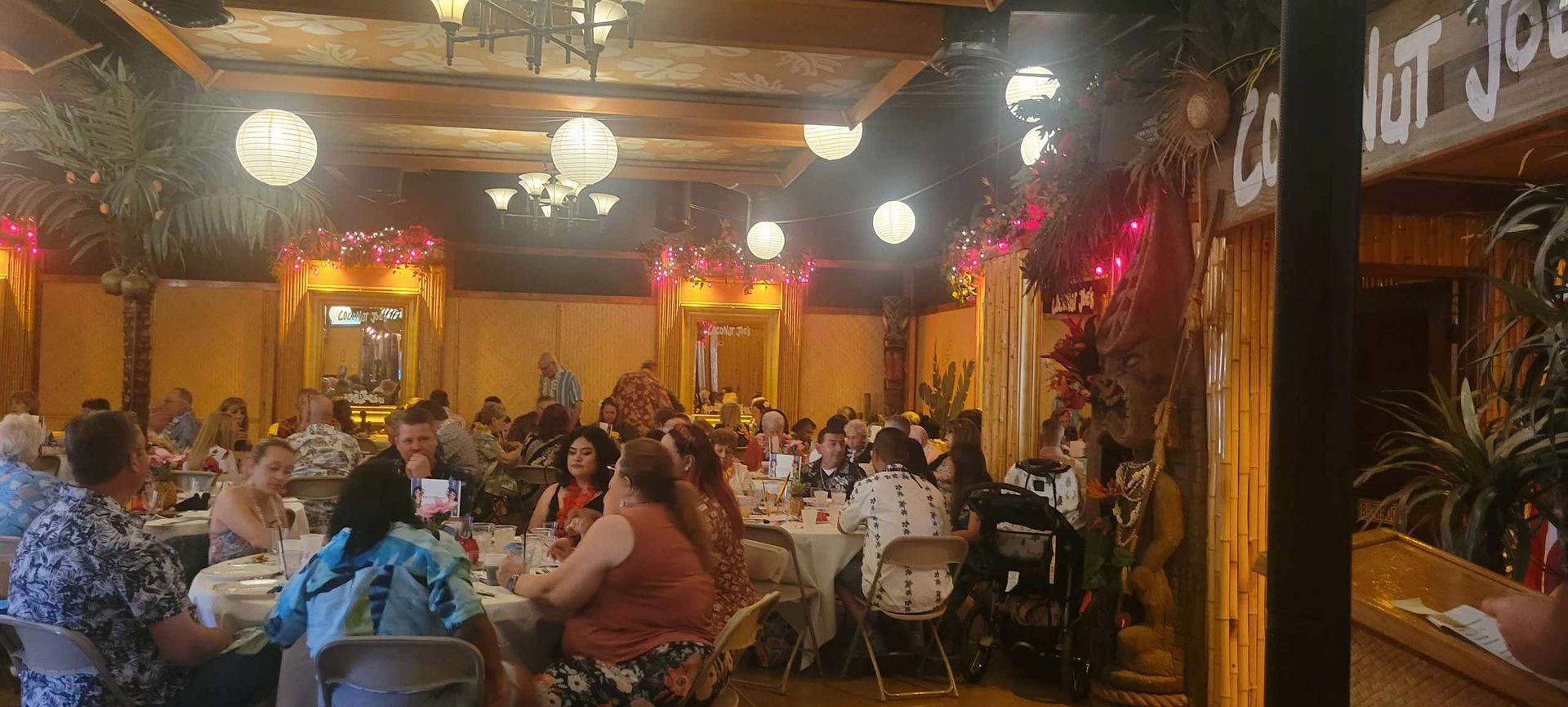 A large group of people are sitting at tables in a large room.