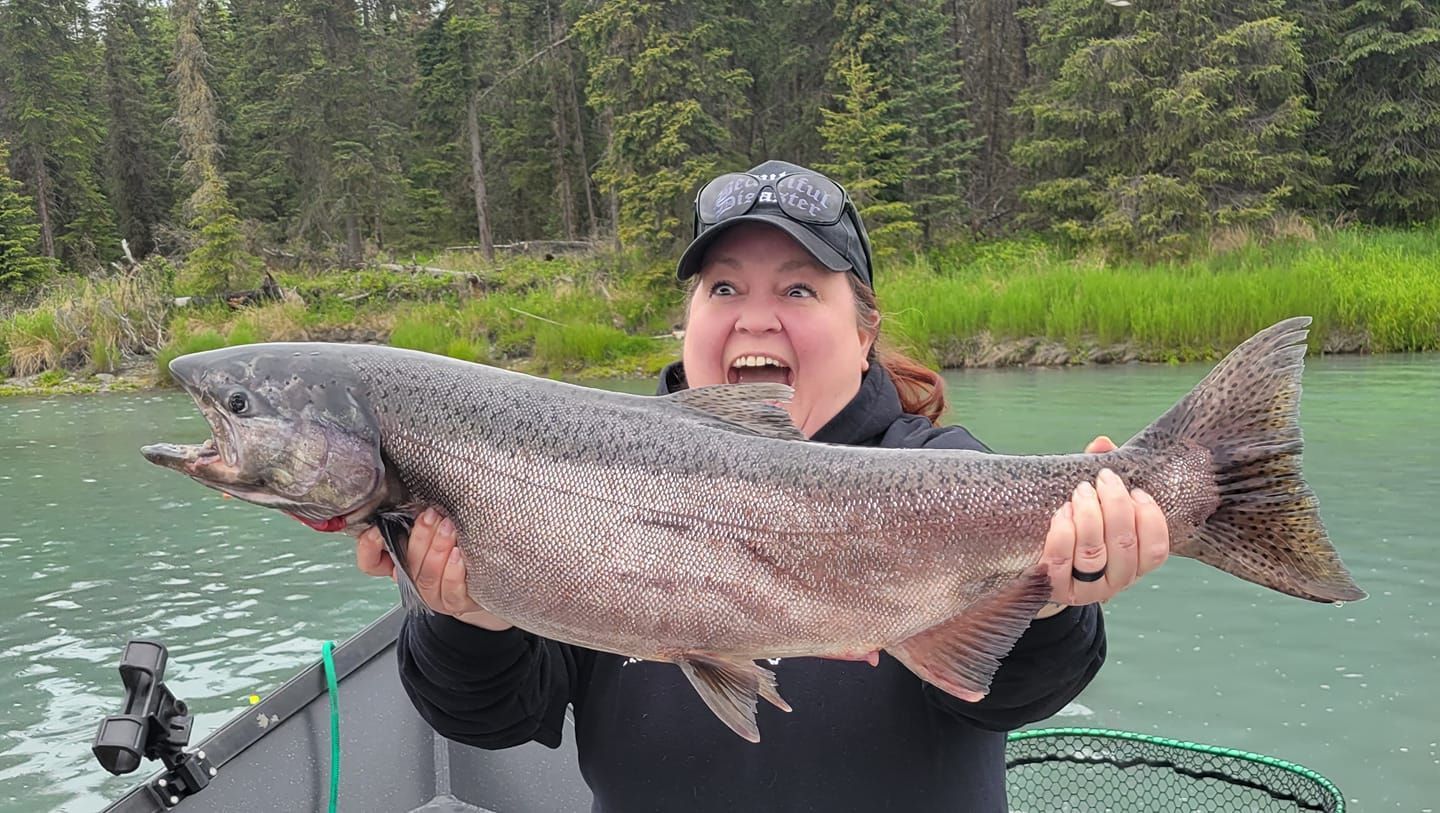 Excited woman holding giant king salmon - Small Town Fishing Adventures - Alaska