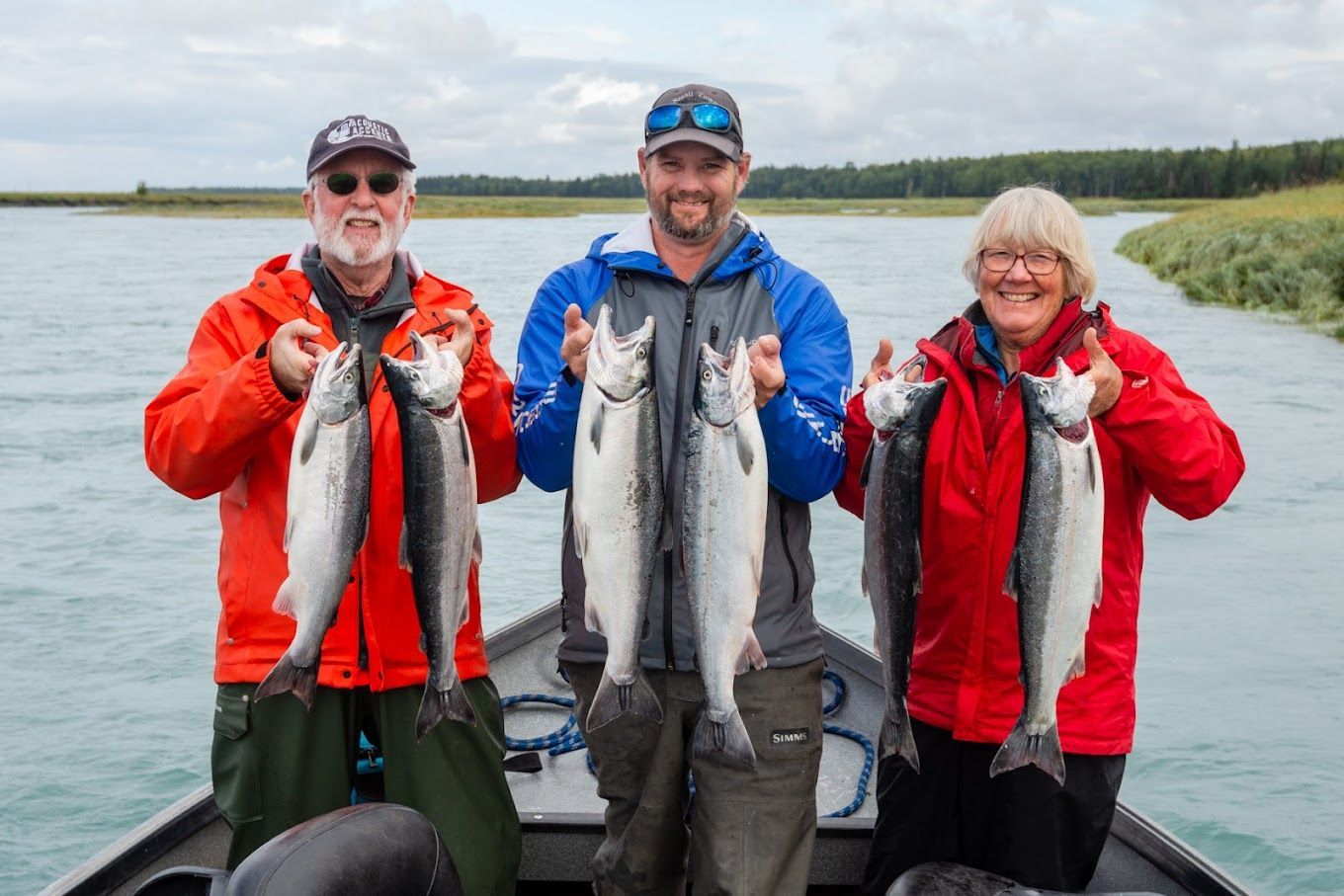 JD Roberts and clients on his fishing tour boat holding silver salmon catch