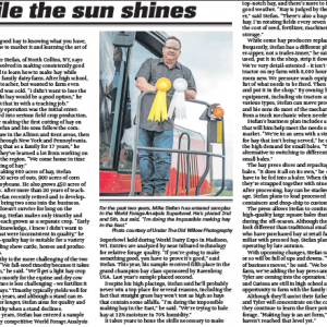 Man standing by hay baler with ribbons; North Collins, NY.
