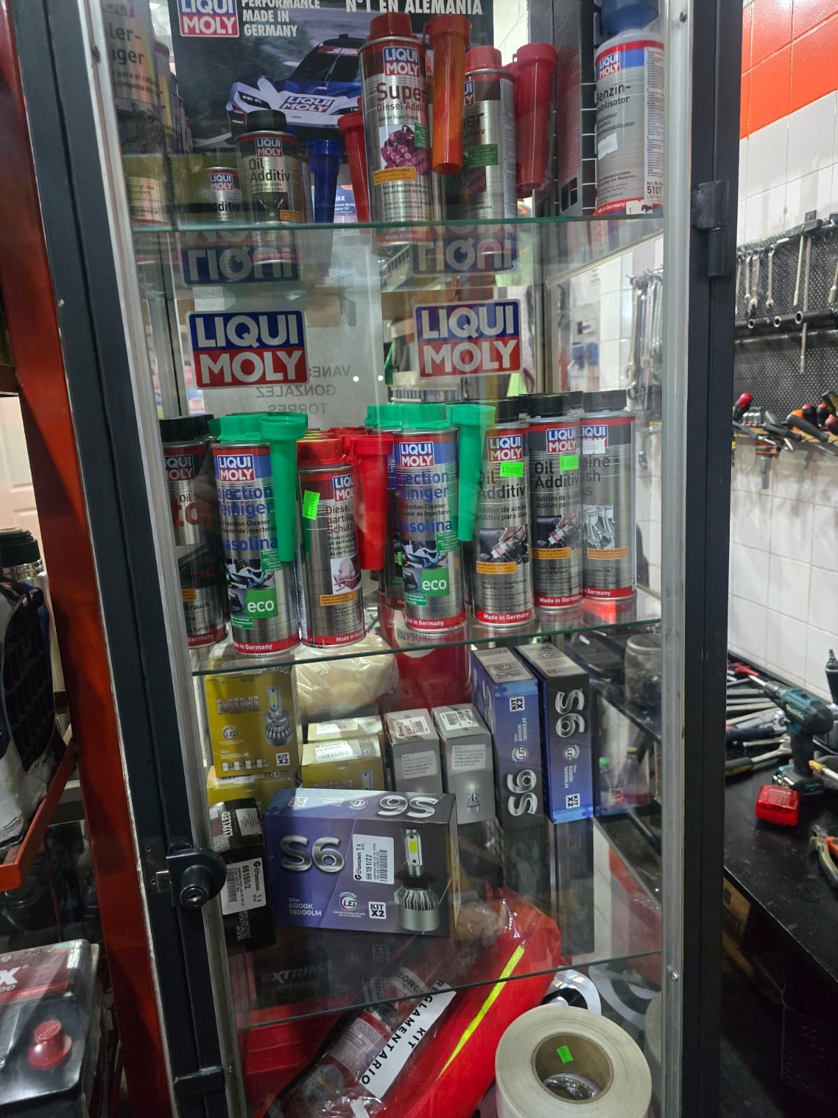 Vitrina de cristal llena de productos Liqui Moly para automoción. Se ven contenedores rojos, azules y verdes.