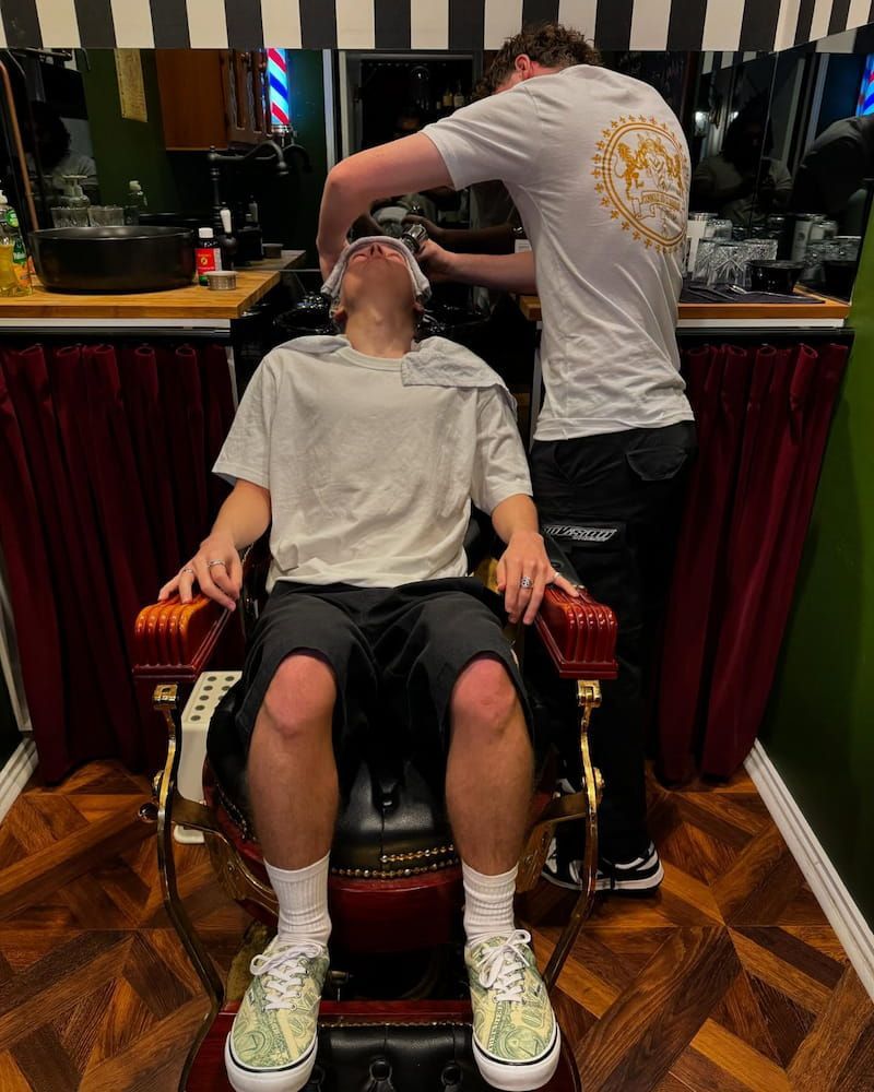 A Man is Getting His Hair Cut by a Barber in a Barber Shop — Connolly & Co Barbers In Robina, QLD