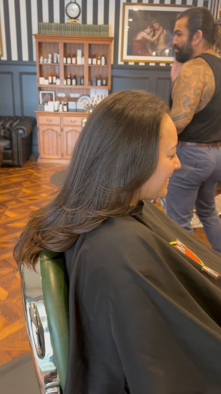 A Woman is Getting Her Hair Cut at a Barber Shop — Connolly & Co Barbers In Robina, QLD