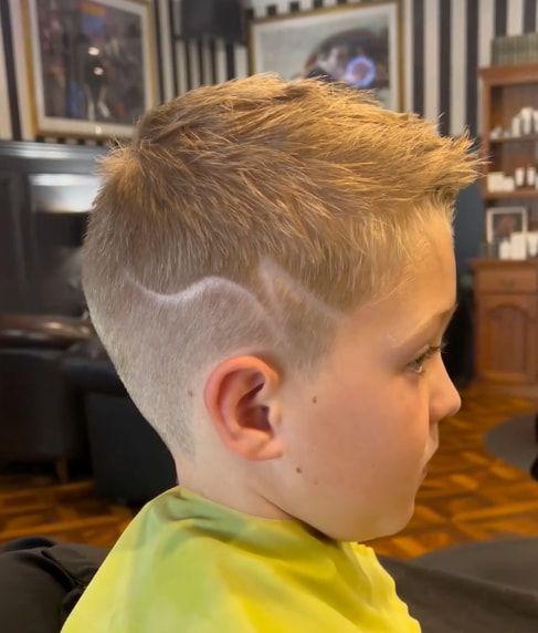 A Young Boy is Getting His Hair Cut at a Barber Shop — Connolly & Co Barbers In Robina, QLD