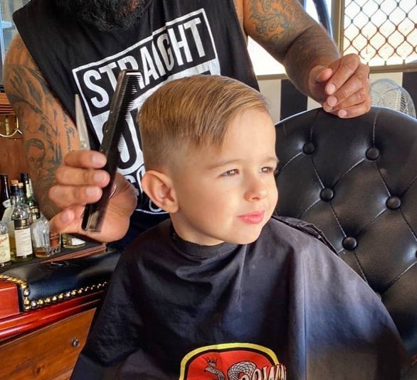 A Little Boy is Getting His Hair Cut by a Man Wearing a Shirt That Says Straight — Connolly & Co Barbers In Robina, QLD