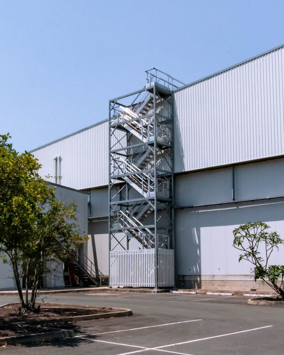 Stair tower with a secure screen for industrial facility roof access