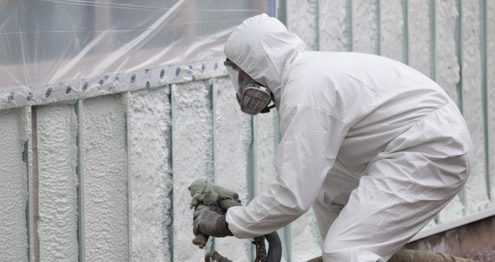 spray foam contactor spraying foam insulation in the basement walls of a house in Newmarket Ontario.