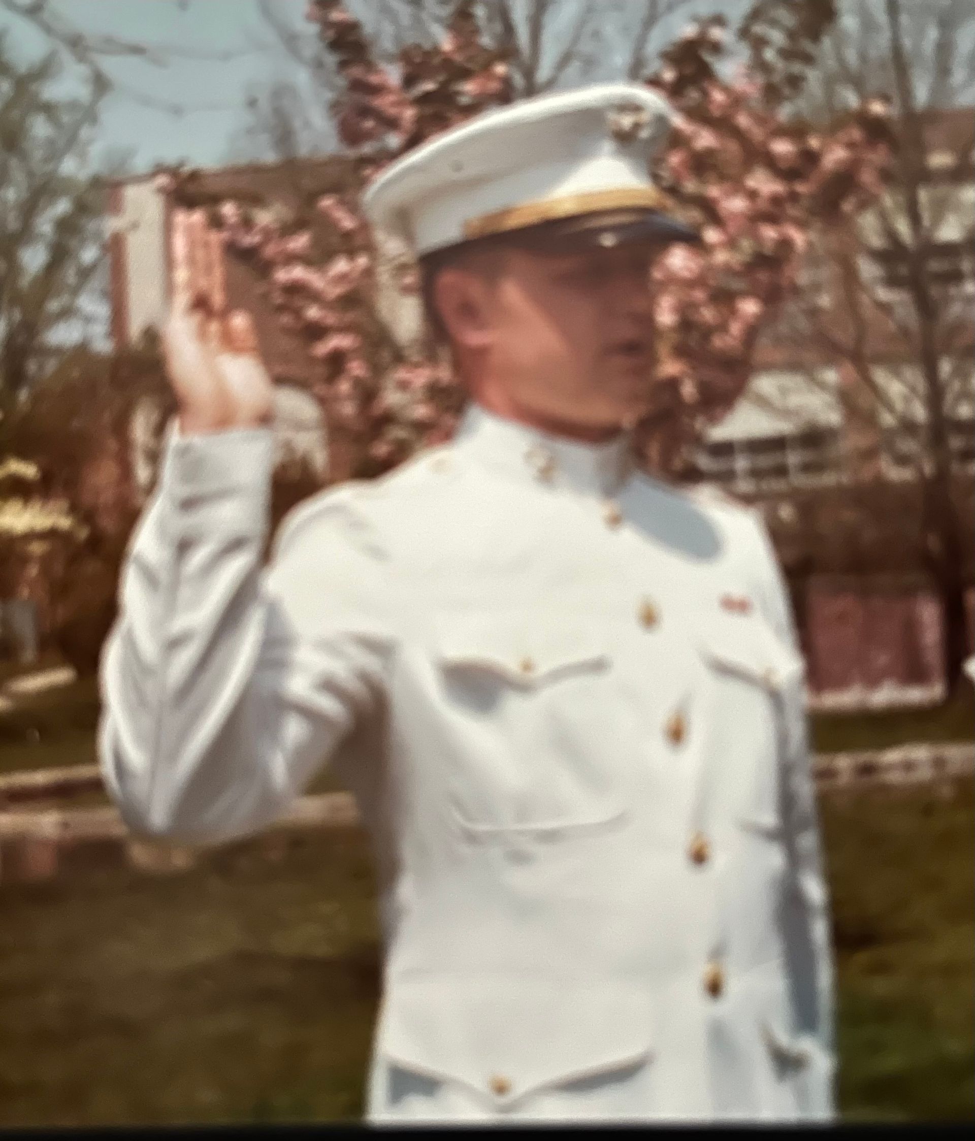 A man in a white uniform is taking an oath